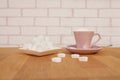 Loose sugar in a pink tea cup and saucer, refined slices, sugar tongs, heart-shaped candies, the concept of excessive sugar