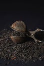 Loose tea on a black background. Loose tea in an old brewing sieve. Royalty Free Stock Photo