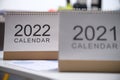 Looseleaf paper calendars for 2021 and 2022 standing on table closeup