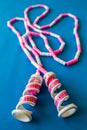 Loosely Laid Pink and White Toy Jump Rope on Blue Background Royalty Free Stock Photo
