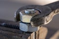 Loosening the nut using a wrench and a vise. Using old spanner wrench and clamp to remove nut from bolt, closeup Royalty Free Stock Photo