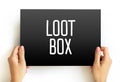 Loot Box text displayed on a rectangular sign held by two hands. Gaming and digital entertainment concept emphasizing rewards, Royalty Free Stock Photo