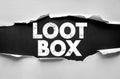 LOOT BOX text exposed through torn paper background in strong typeface, representing gaming rewards, virtual items, entertainment Royalty Free Stock Photo