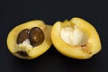 Loquat fruit cut in half on black background Royalty Free Stock Photo