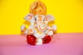 Lord ganesh or ganesha Idol in plain yellow background with specific focus on ganesha