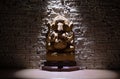 Lord Ganesha. ganesh statu on wooden table under direct light on beigh wall background