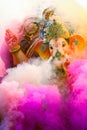 Lord Ganesha idol covered in colored smoke