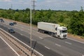 Lorry carrying refrigerated shipping container in motion on British motorway M25