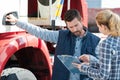 lorry driver taking instructions from female colleague with clipboard