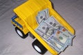 The lorry the dump truck with money in a body dollars yellow color a wheel black Royalty Free Stock Photo