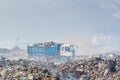 Lorry full of refuse at the garbage dump full of smoke, litter, plastic bottles,rubbish and trash at tropical island