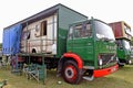 A lorry with a small caravan inside the trailer on the back