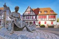 Lorsch, Germany, Fountain called `Tabakbrunnen` showing a tobacco seamstress at town square with traditional half timbered buildin
