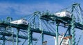 Tall gantry cranes in the industrial Port of Los Angeles, California with the bridge of a container ship visible Royalty Free Stock Photo