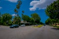 Los Angeles, California, USA, JUNE, 15, 2018: Palm trees street in Beverly Hills and cars circulating in the roads of Royalty Free Stock Photo