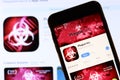 Los Angeles, California, USA - 28 November 2019: Plague Inc app icon on mobile phone screen with logo on laptop on blurry