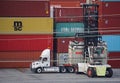 A fork lift operator moves a shipping container from a truck in a freight terminal, Port of Los Angeles, California.