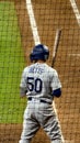 Los Angeles Dodgers baseball player Mookie Betts standing at home plate holding a bat surrounded by an umpire other players