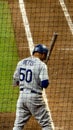 Los Angeles Dodgers baseball player Mookie Betts standing at home plate holding a bat surrounded by an umpire other players