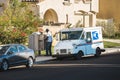 LOS ANGELES, UNITED STATES - Nov 17, 2020: US Postal Service worker delivers mail to a community mailbox in Los Angeles,