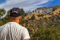 LOS ANGELES, USA - July 5, 2018, a tourist looking thoughtfully at the Hollywood sign on the Hollywood hills in California, the