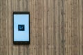 Adobe photoshop lightroom logo on smartphone screen on wooden background. Royalty Free Stock Photo