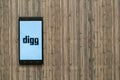 Digg logo on smartphone screen on wooden background.