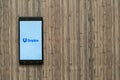 Dropbox logo on smartphone screen on wooden background.