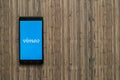 Vimeo logo on smartphone screen on wooden background.