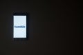 Tumblr logo on smartphone screen on black background.