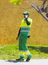 Los Cristianos Teneriffe A local council environmental worker wearing full high visibility protective clothing on a mobile phone