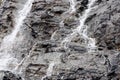 ÃÂ¡lose-up monochrome shot of flowing and foaming waters of small alpine cascade over gray karst layers of granite