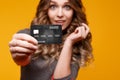 Lose-up portrait of happy young brunette woman holding credit card and colorful shopping bags, looking at camera Royalty Free Stock Photo
