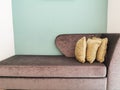 lose up view of sofa with pillow on the sofa and plain green wall in the background