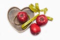 Lose Weigh. Close Up of Measuring Yellow Tape Ties Around Red Apples in Wooden Heart shape box. Isolated on white background. hori Royalty Free Stock Photo