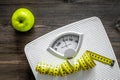 Lose weight concept. Bathroom scale, measuring tape, apples on wooden background top view Royalty Free Stock Photo