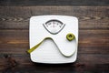 Lose weight concept. Scale and measuring tape on dark wooden background top view Royalty Free Stock Photo