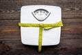Lose weight concept. Scale and measuring tape on dark wooden background top view Royalty Free Stock Photo