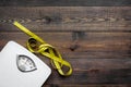 Lose weight concept. Scale and measuring tape on dark wooden background top view copy space Royalty Free Stock Photo