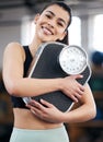 Lose weight, gain confidence. Portrait of a fit young woman holding a scale in a gym. Royalty Free Stock Photo