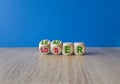 Loser or leader symbol. Turned cubes and changes green words loser to leader. Beautiful wooden table, blue background. Business