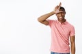 Losers stay home. Friendly-looking joyful and confident young african american male student in pink polo shirt showing