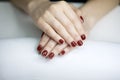 ÃÂ¡loseup of hands of a young woman with long red manicure on nails