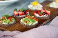 ÃÂ¡loseup macro set of different northern trendy appetizers on smorrebrod rye bread with red caviar and avocado, strawberries,