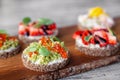 ÃÂ¡loseup macro set of different northern trendy appetizers on smorrebrod rye bread with red caviar and avocado, strawberries,