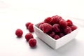 ÃÂ¡loseup of pile of ripe raspberries, white square bowl full of juicy raspberries