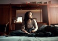 Really losing herself in the story. young woman deep in thought while reading a book in bed.