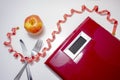 Losing weight concept. Weight scale with a fork, knife, red measuring tape and an apple Royalty Free Stock Photo