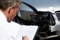 Loss Adjuster Inspecting Car Involved In Accident