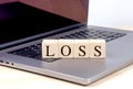 LOSS word on wooden block on laptop , business concept